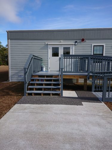 Exterior view of entrance to a modular office building with ramp and stairs